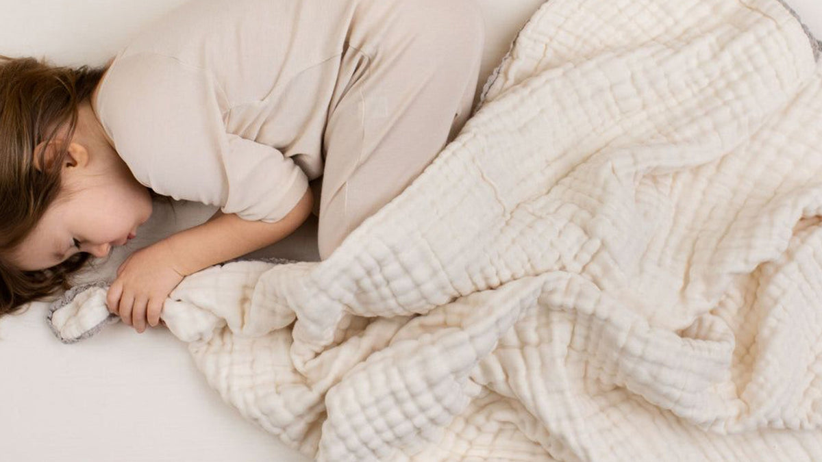 Organic cotton muslin bedding layered on a bed